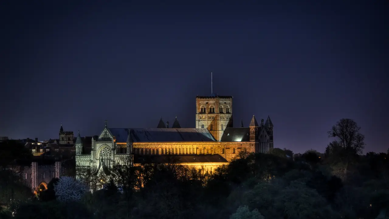 St Albans Cathedral lit up against the evening sky